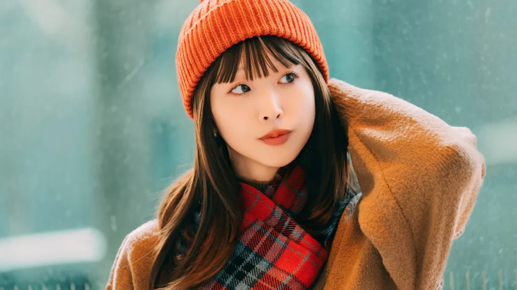 オレンジのニット帽をかぶった女性