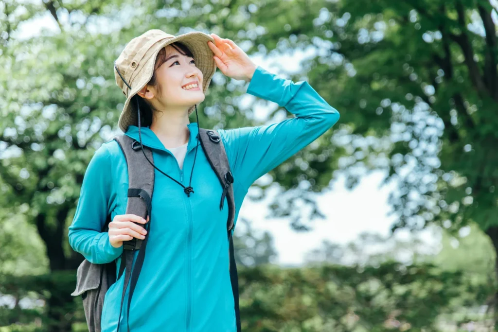 フリースを着て山道で空を見上げる女性